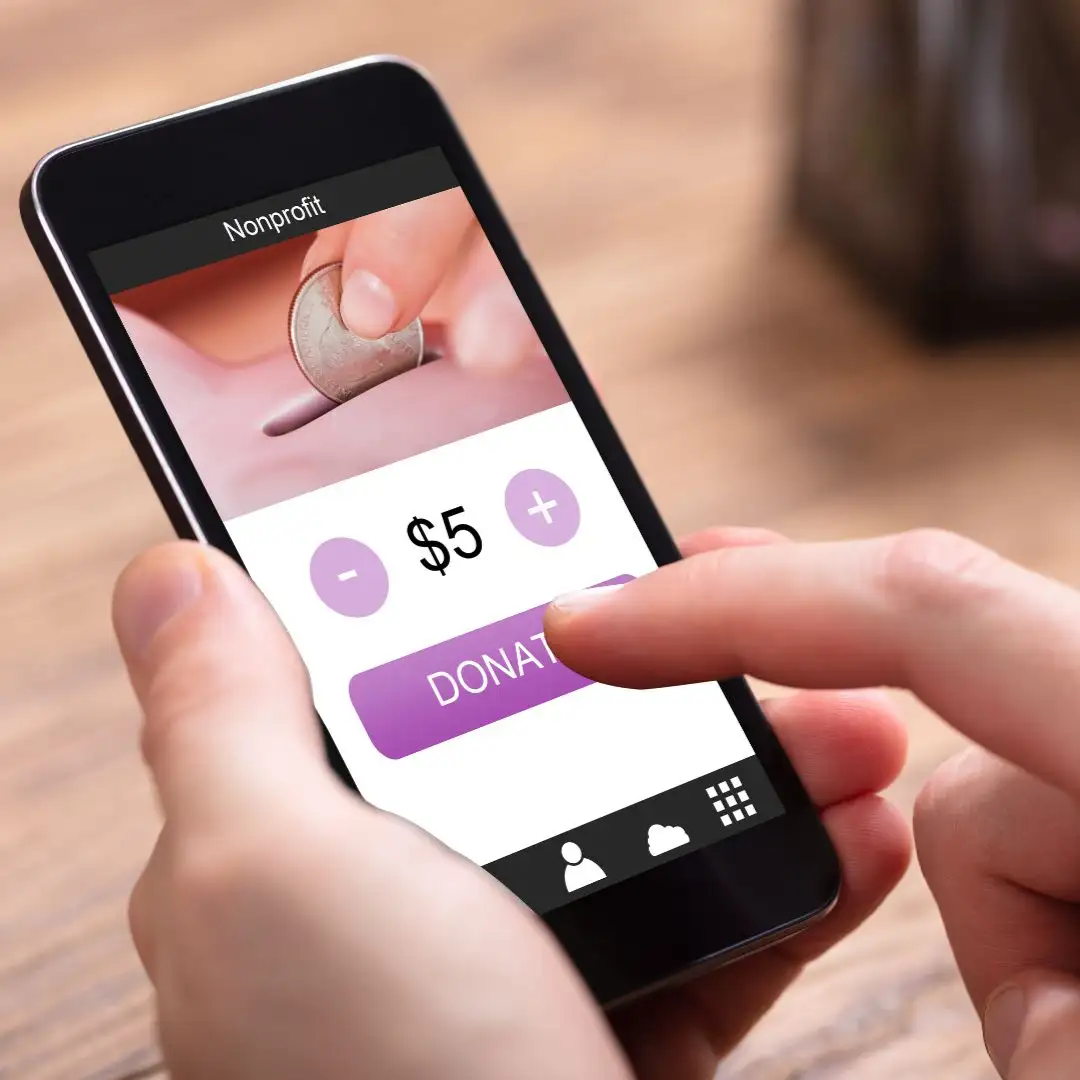 Hand tapping a donate button on a phone